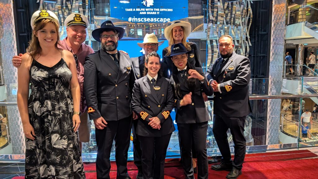 Ken and Andrea posing with MSC Seascape officers during the Officer Selfie event in the ship's atrium on the final evening of the cruise.