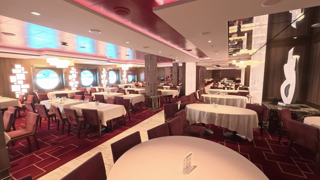 Cala Jondal Restaurant aboard MSC Seascape featuring elegant dining tables, modern décor, large porthole windows, and seating for evening dining service.
