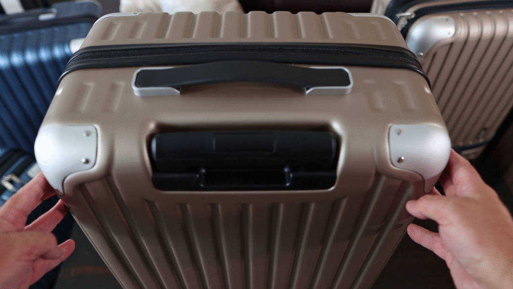 Close-up of the Level8 Grace luggage in Champagne showing the reinforced protective corner guards, textured hard-shell exterior, durable zipper, and modern ribbed design.