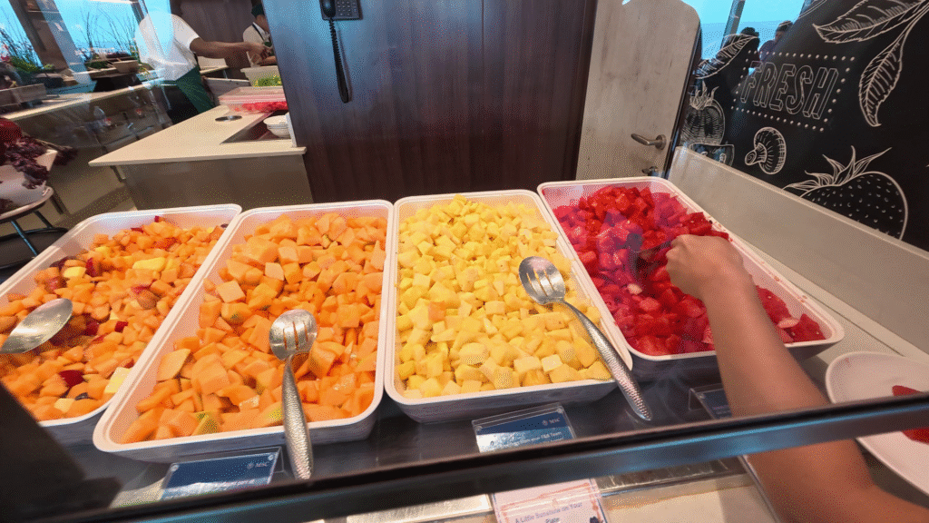 Fresh pre-cut fruit including watermelon, pineapple, cantaloupe, and mixed fruit available at the MSC Seascape Marketplace Buffet.