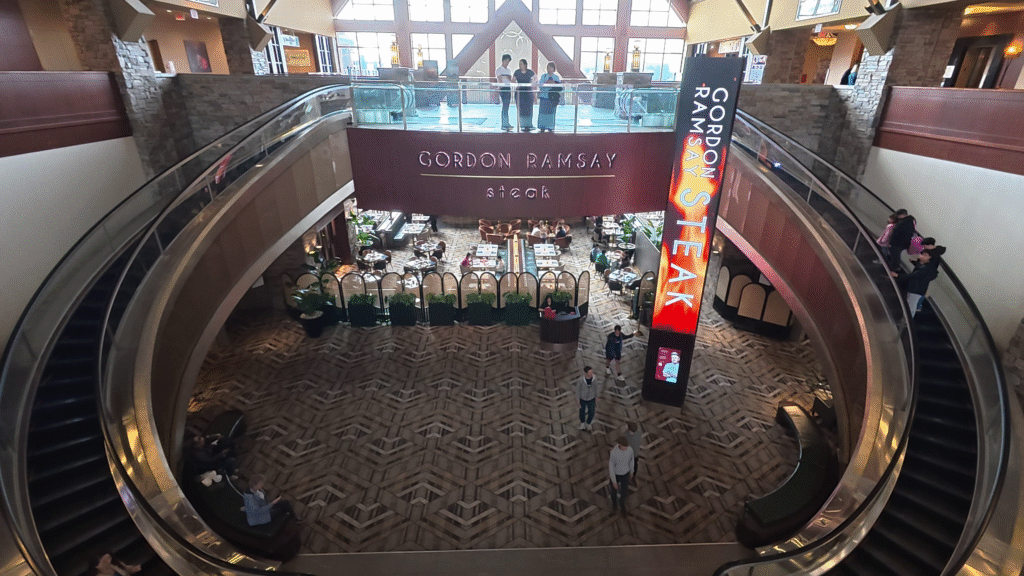 Grand lobby at the River Rock Casino Resort in Richmond, British Columbia, featuring curved escalators, soaring ceilings, and Gordon Ramsay Steak restaurant.