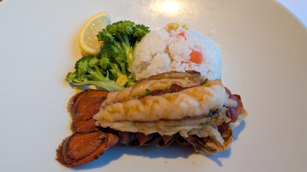 Complimentary lobster tail served with rice and broccoli during Evening Chic night in the Grand Epernay Restaurant on Celebrity Solstice.