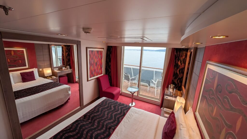 MSC Poesia aft balcony cabin 11250 with a bed, seating area, and balcony doors.