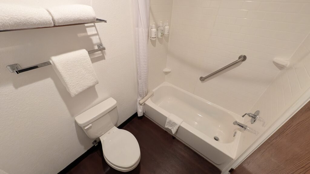 Toilet and bathtub with shower inside our Ramada Spokane Airport bathroom.