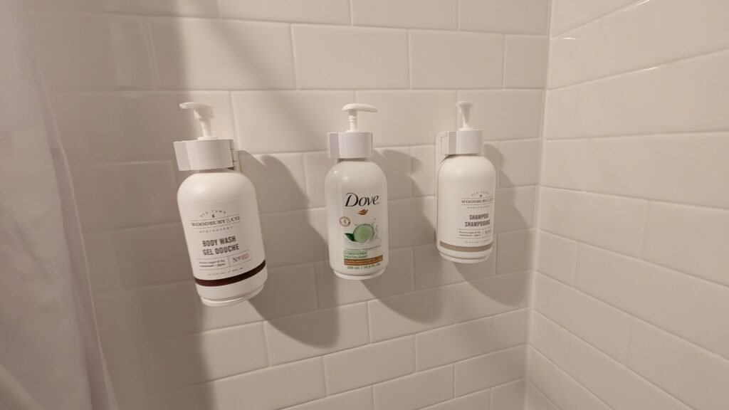 Shampoo, conditioner, and body wash dispensers in Ramada Spokane Airport shower.