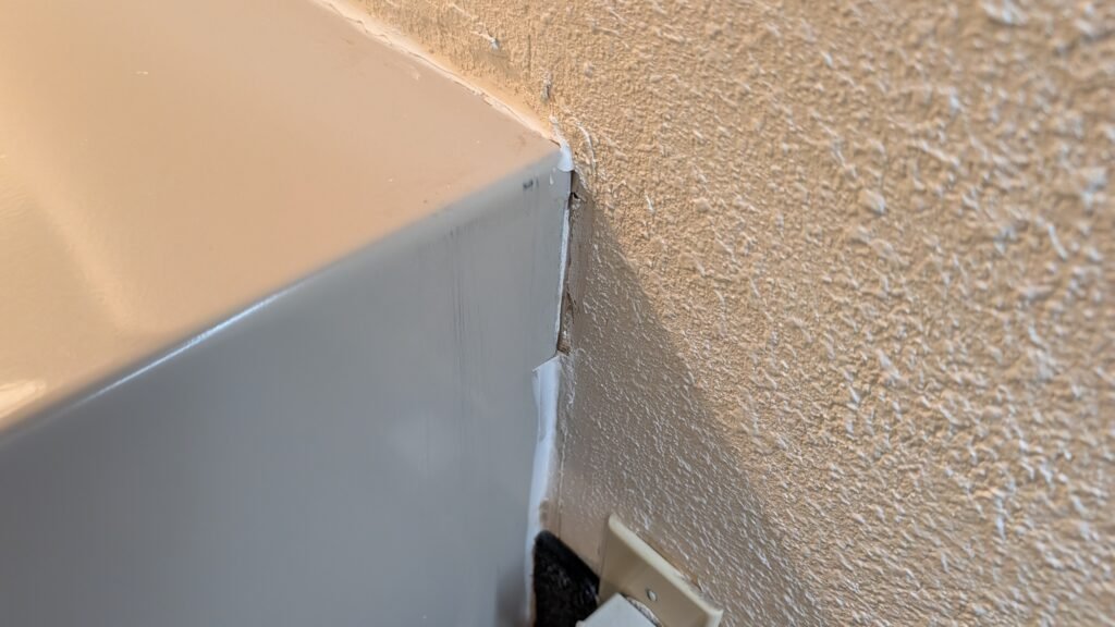 Uneven silicone sealant around the air conditioning unit at Ramada Spokane Airport.