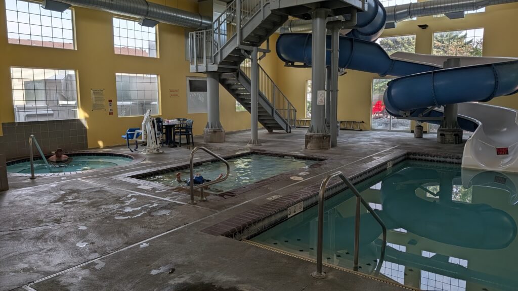 Indoor pool, waterslide, and two hot tubs at Ramada by Wyndham Spokane Airport.