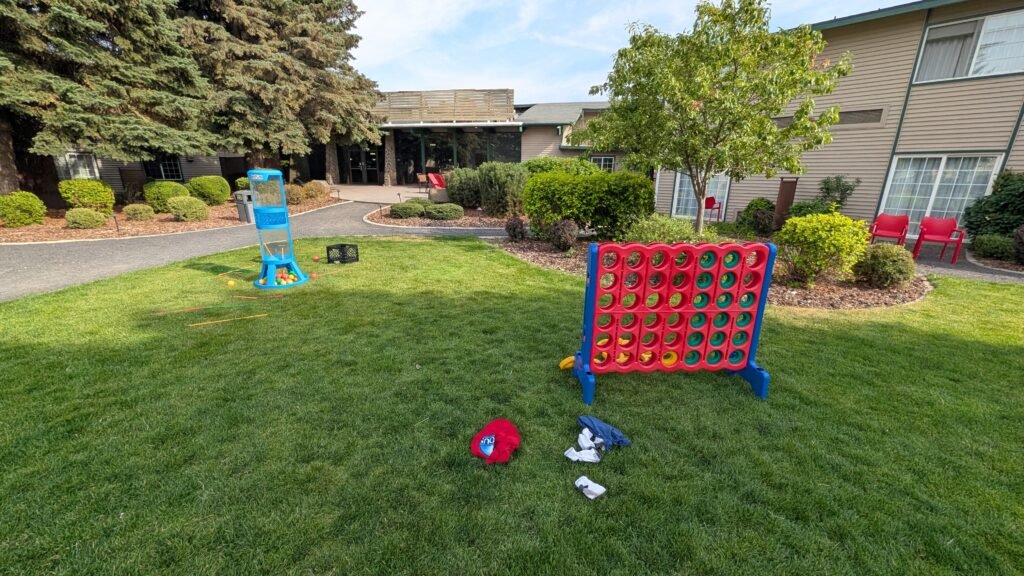 The landscaped courtyard features a fire pit surrounded by bright red Adirondack chairs for guests to relax outdoors.
