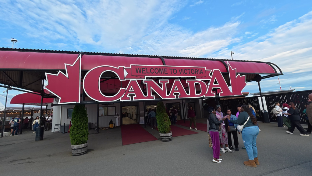 Large red Welcome to Victoria, Canada sign with maple leaves at the cruise terminal in Victoria, British Columbia.